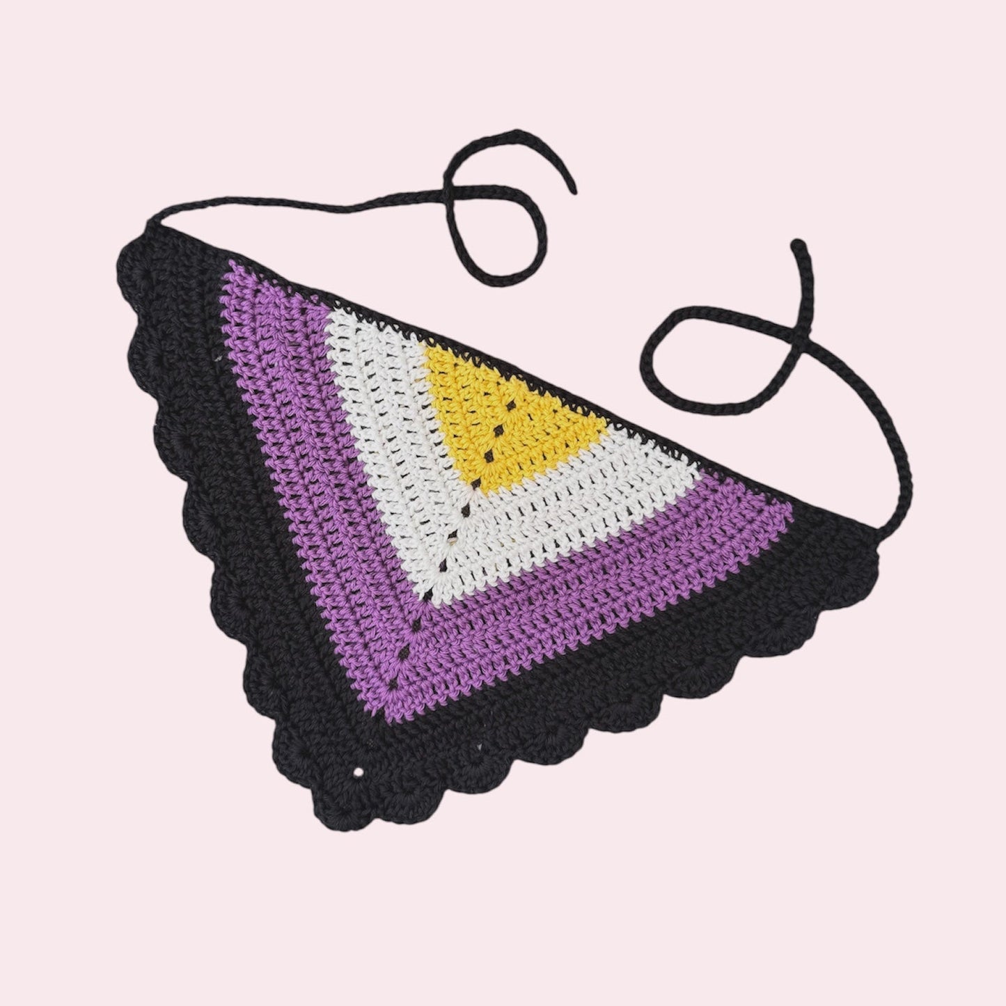 Crochet bandana in nonbinary pride colors on a pink background
