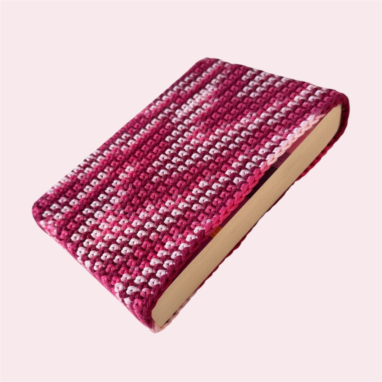Pink book sleeve with a book inside on a pink background