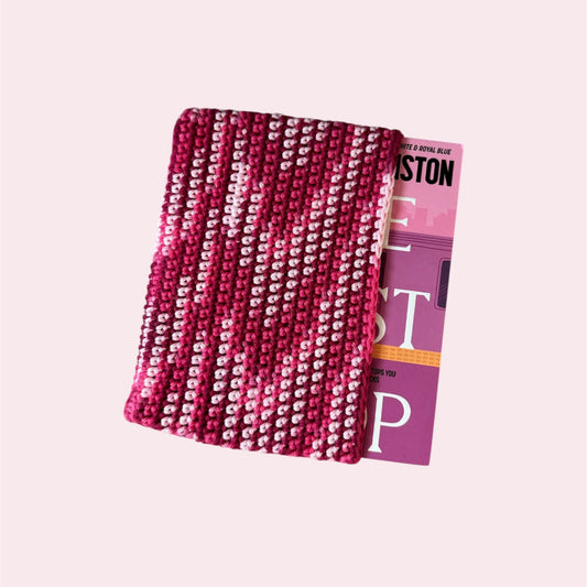 Pink book sleeve with a book inside on a pink background
