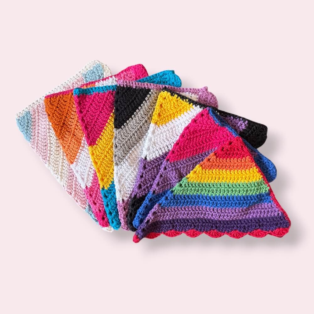 A stack of crochet pride hair bandanas on plain background