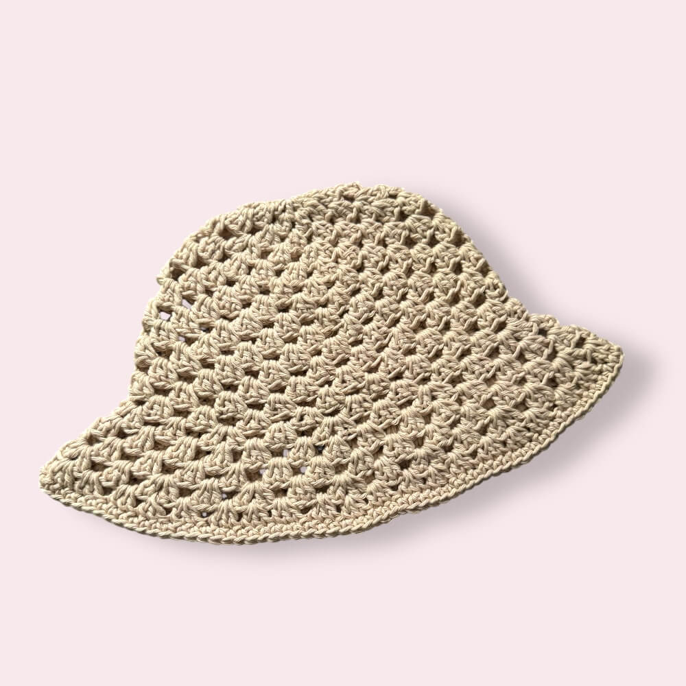 Beige crochet bucket hat on plain background