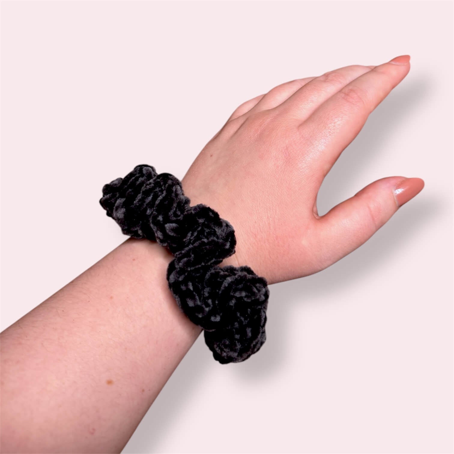 Black crochet scrunchie modeled on wrist