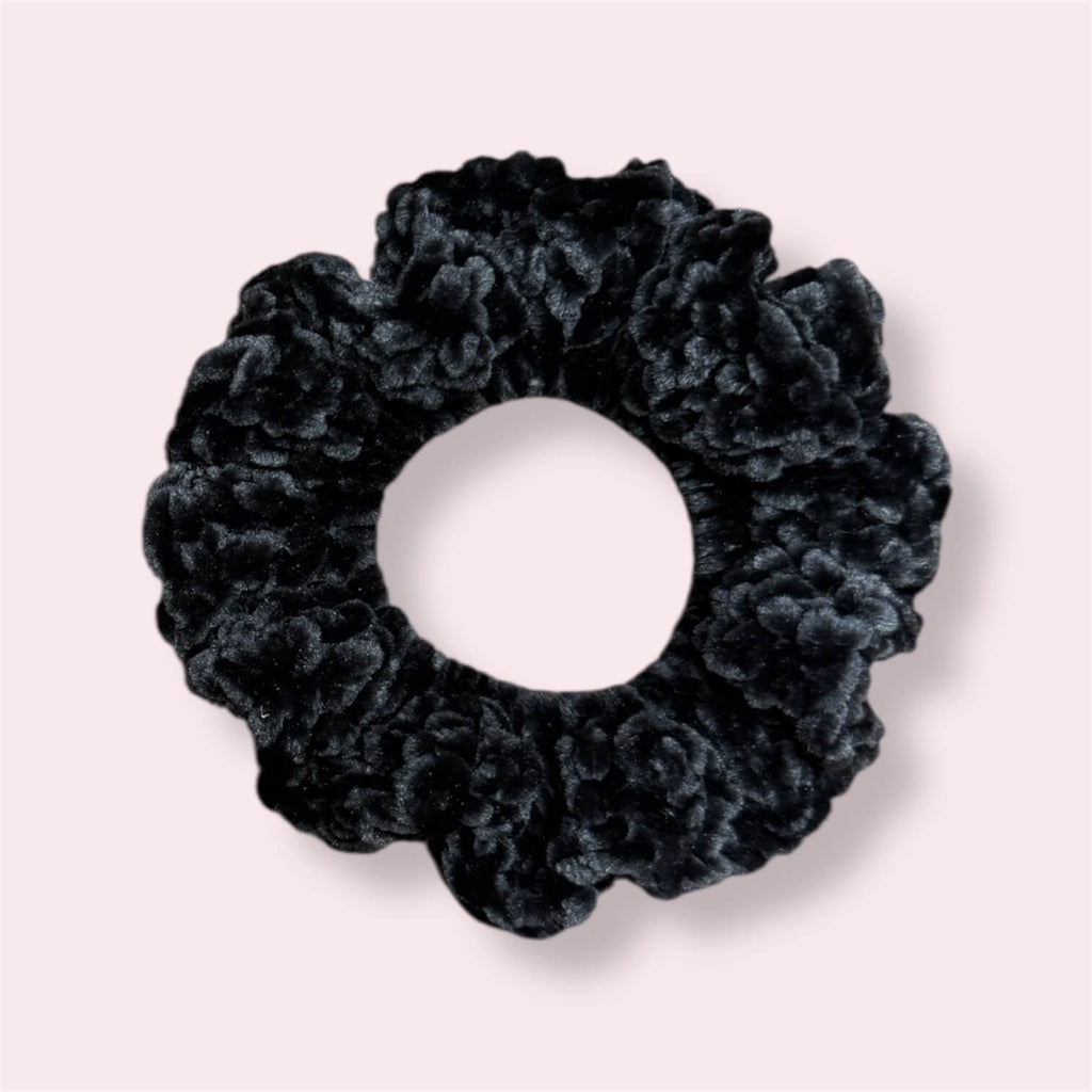 Black crochet scrunchie on plain background