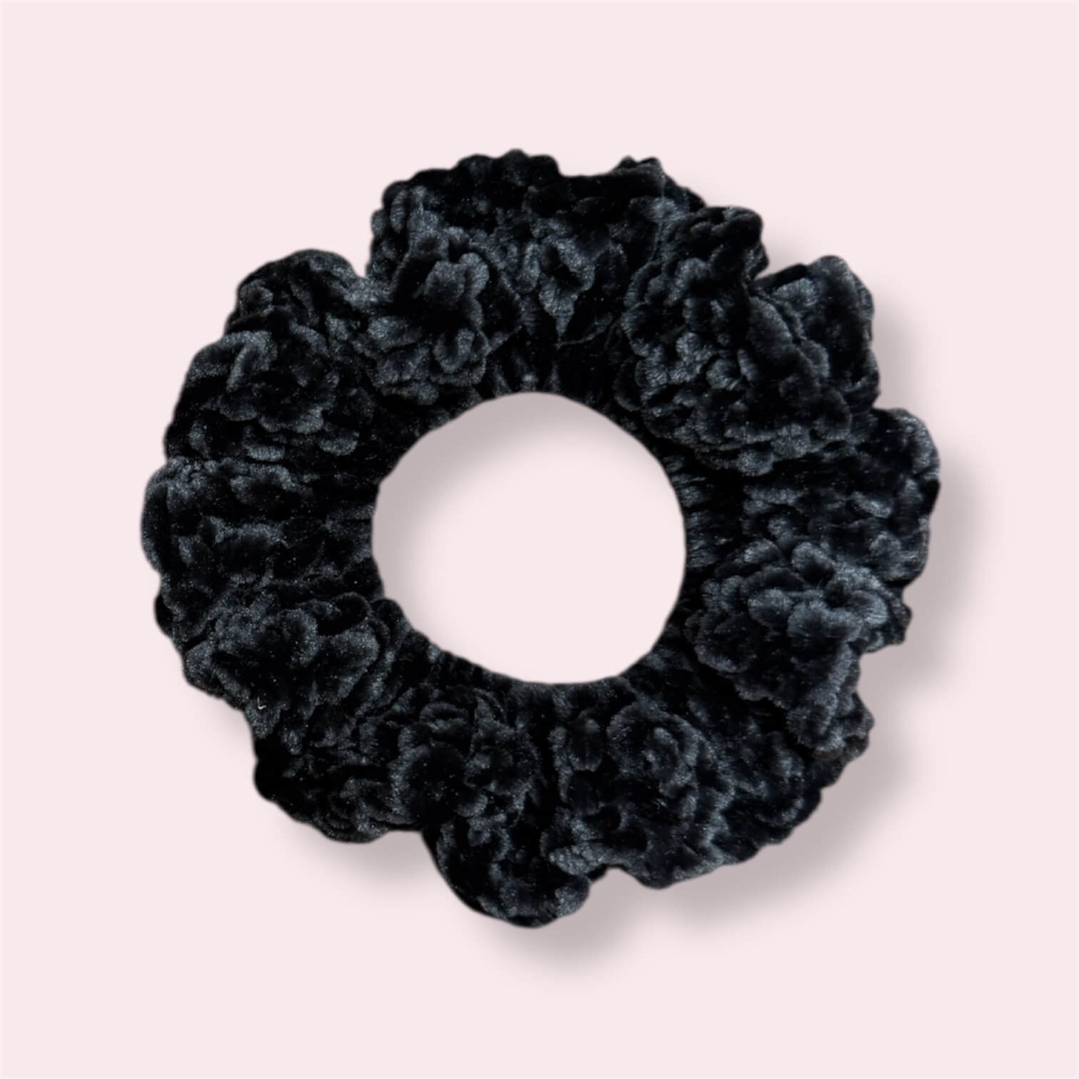 Black crochet scrunchie on plain background