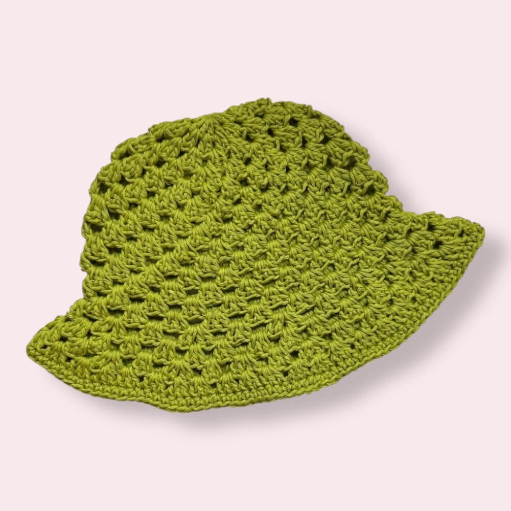 Bright green crochet bucket hat on plain background