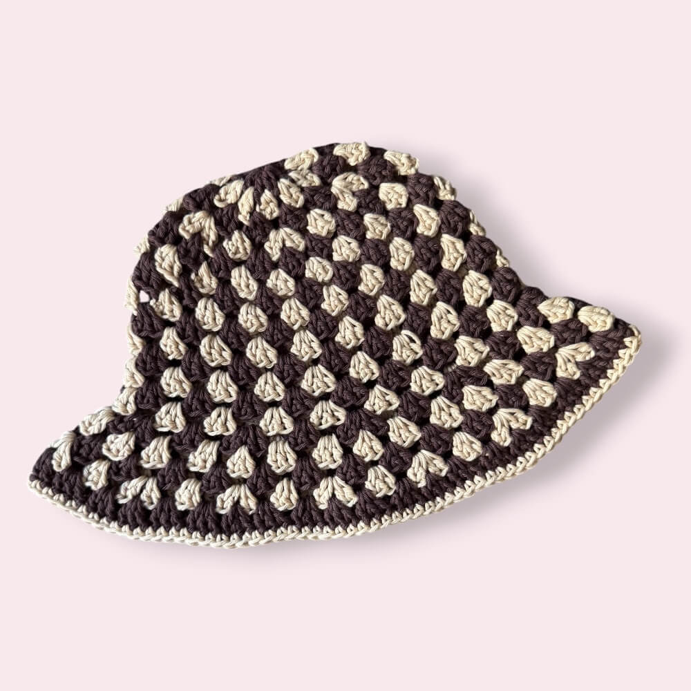Brown striped crochet bucket hat on plain background