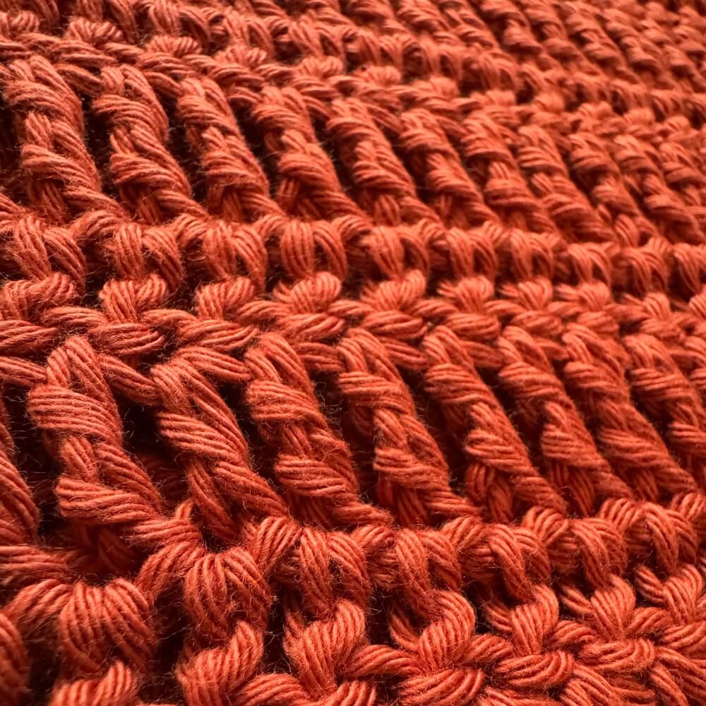 Close up texture shot of crochet orange tee