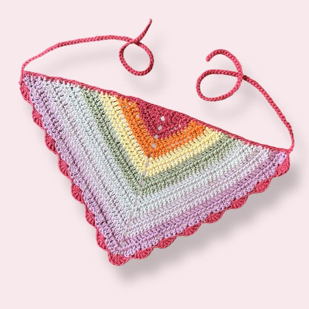 Crochet bandana in pastel rainbow pride colors on plain background