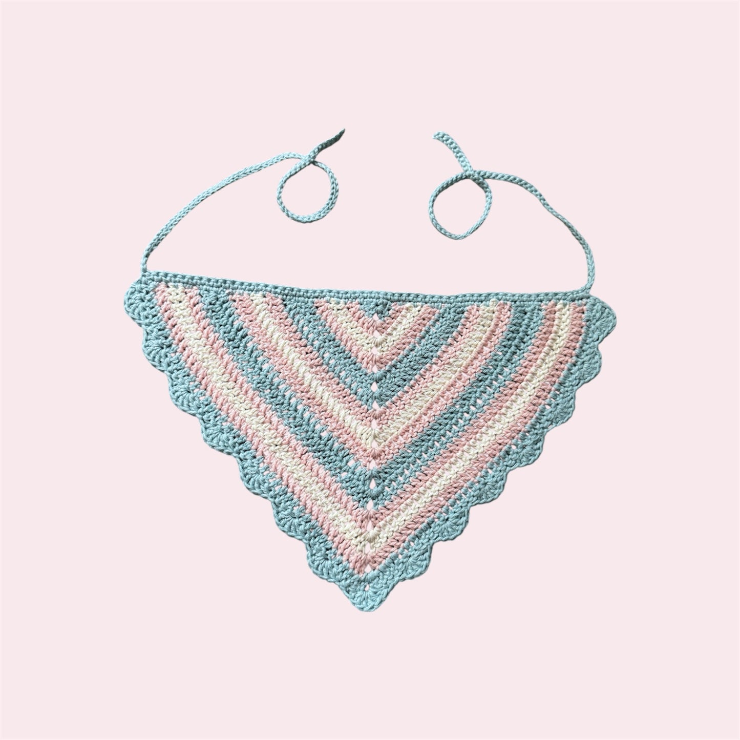 Crochet bandana in trans pride colors on a pink bakground