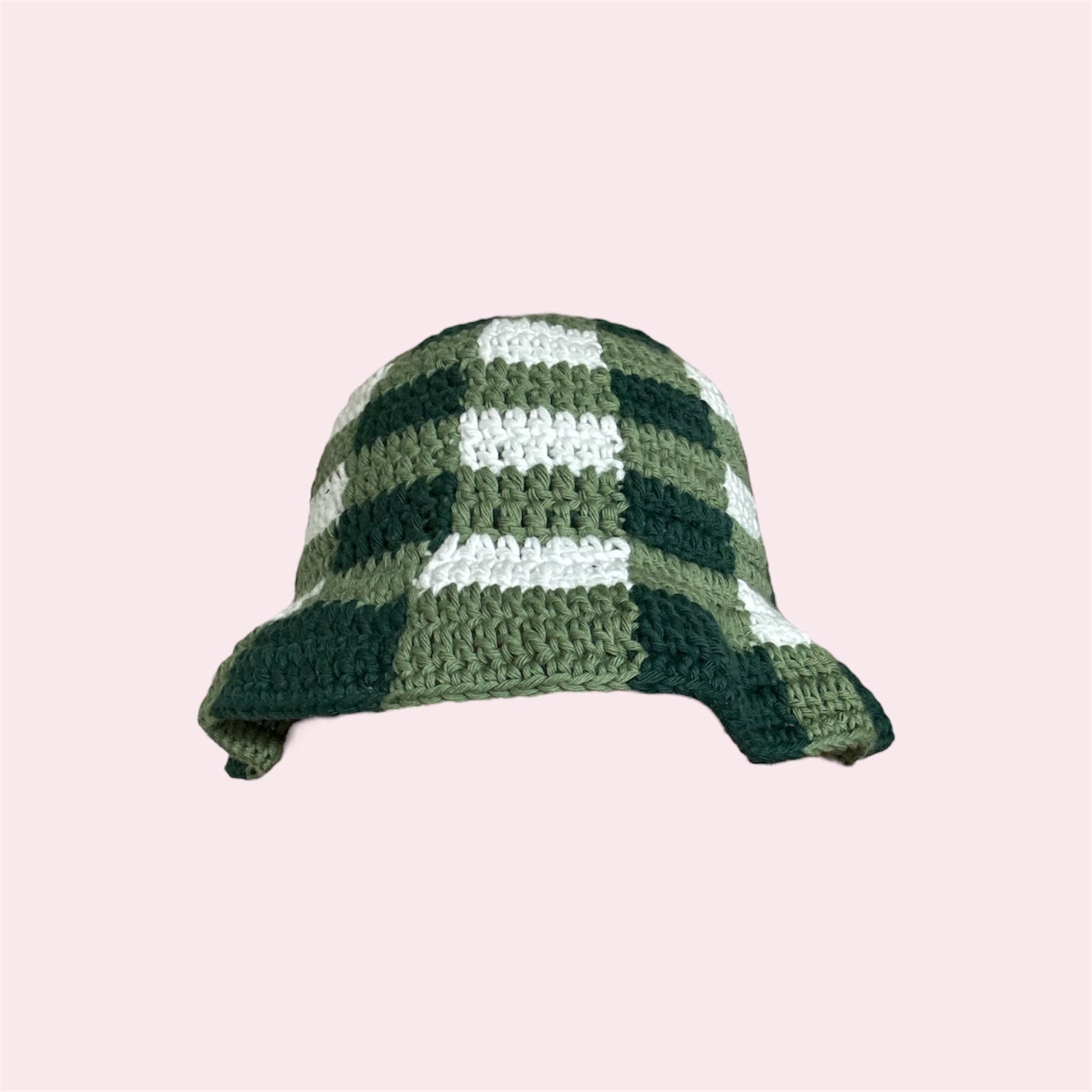 Crochet bucket hat with green gingham pattern on a pink background