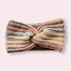 Crochet headband in neutral colors on a plain background
