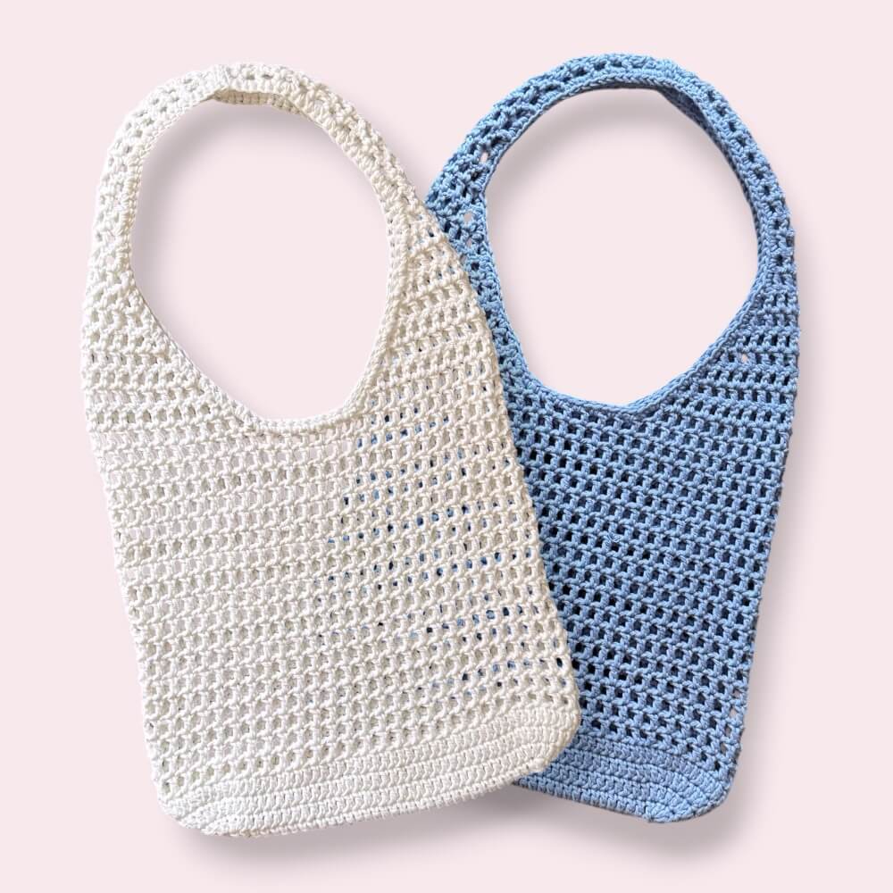 Crochet mesh tote bags on plain background
