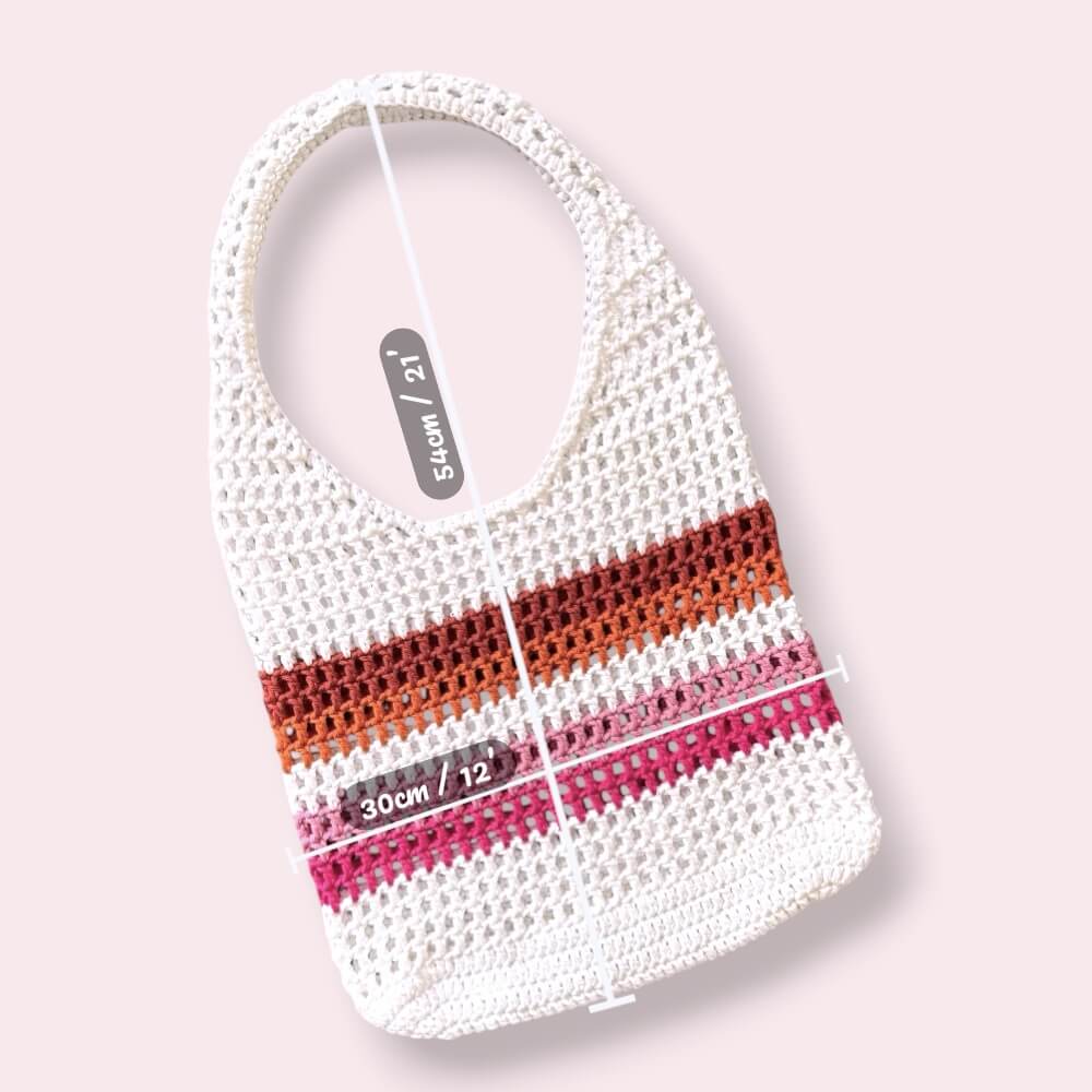 Crocheted lesbian pride mesh tote bag with white, orange, and pink stripes with measurements on a light pink background