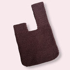 Flatlay of brown japanese knot bag on plain background