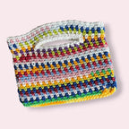 Flatlay of multicolor crochet purse on pink background