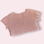 Flatlay of pink crochet tshirt on plain background