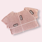 Flatlay of pink crochet tshirt on plain background with measurements