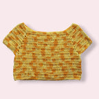 Flatlay of yellow crochet tee on plain background 