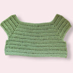 Green crochet crop top on a plain background