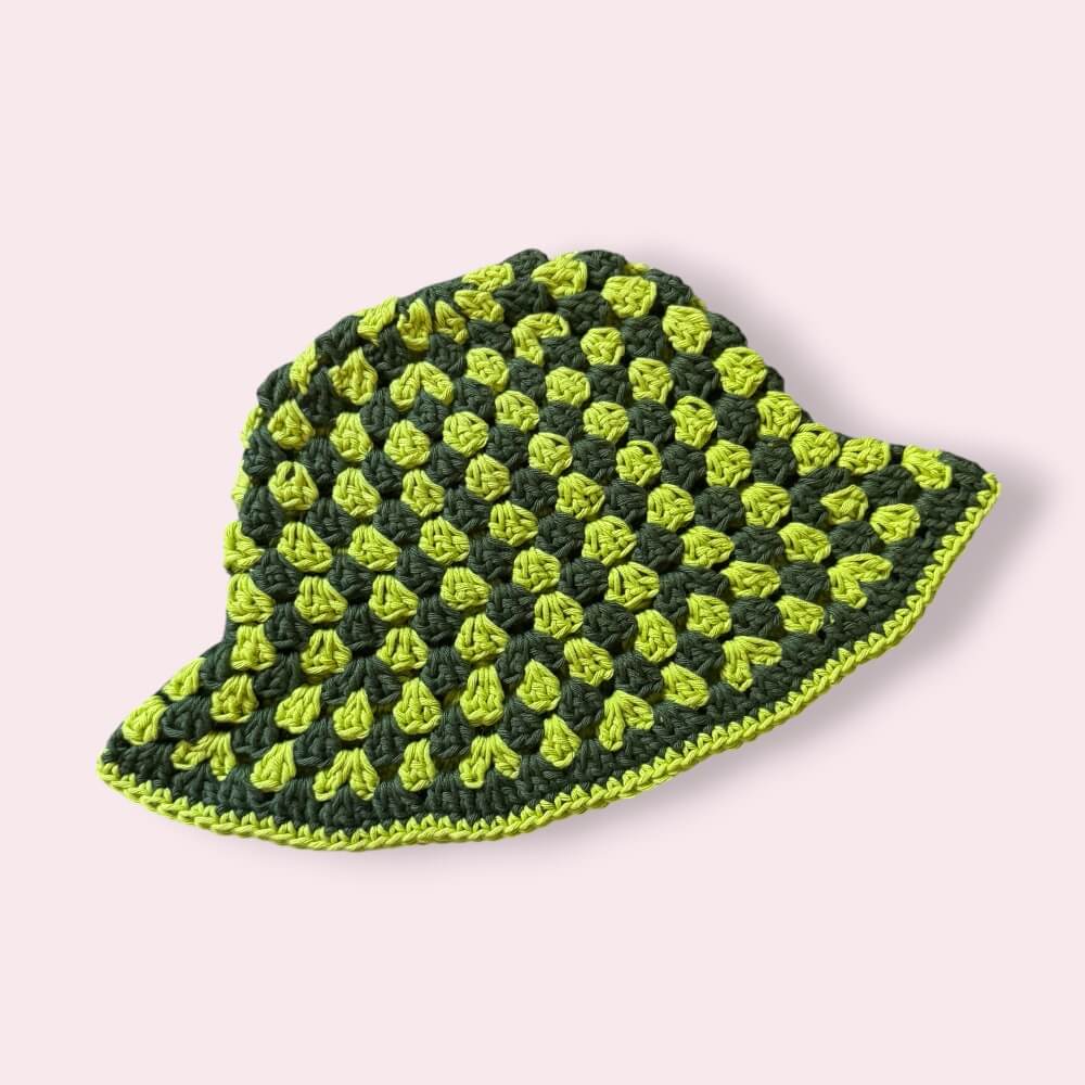Green striped crochet bucket hat on plain background