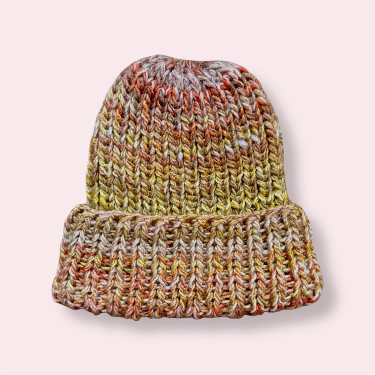 Knit beanie in yellow, pink and orange colors on plain background