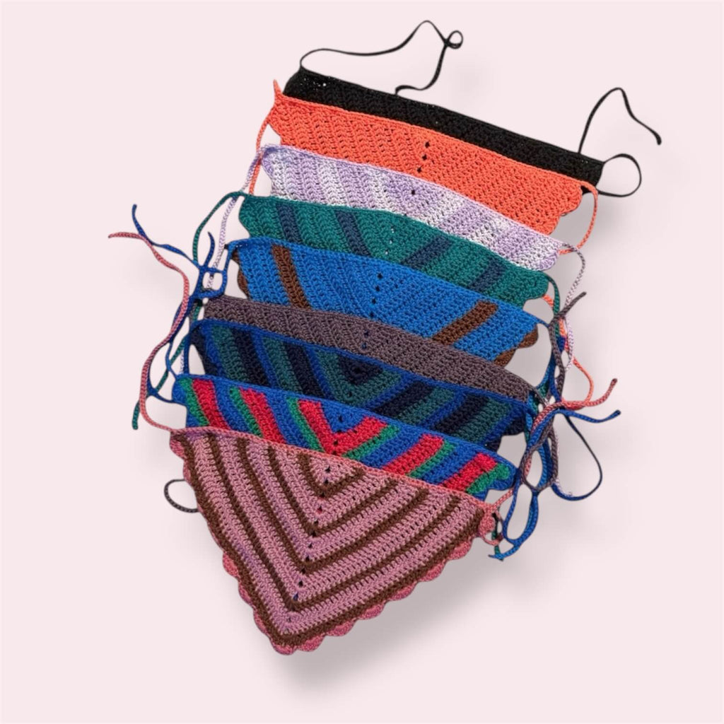 Many crochet bandanas in different colors on plain background