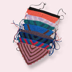 Many crochet bandanas in different colors on plain background