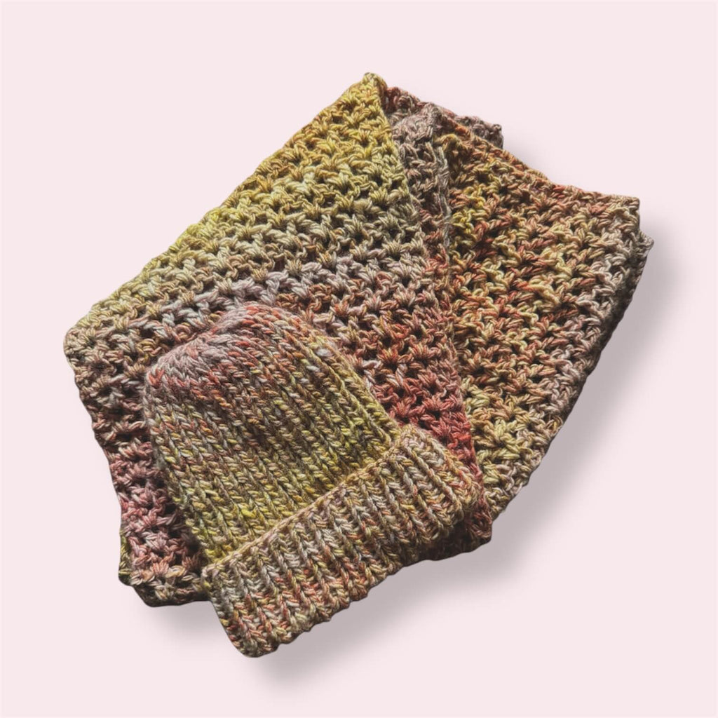 Multicolor handmade scarf and beanie displayed on plain background