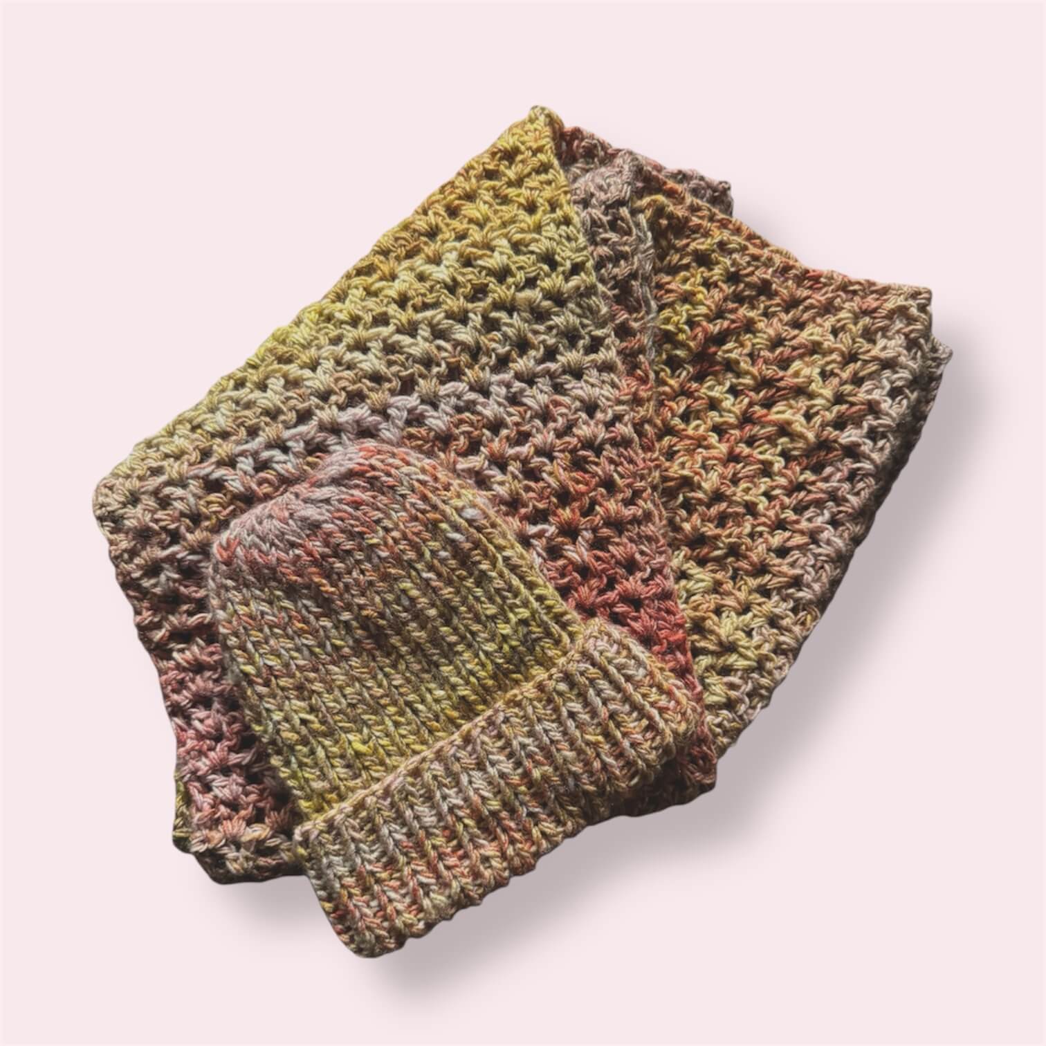 Multicolor handmade scarf and beanie displayed on plain background