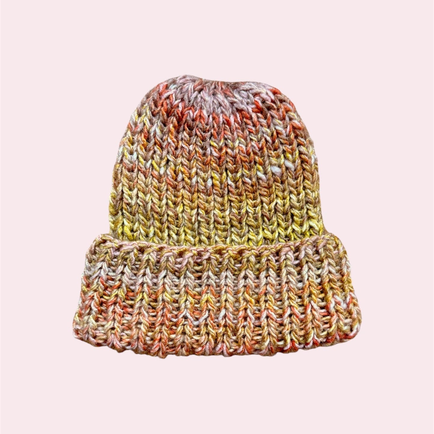 Multicolored knit beanie on a light pink background