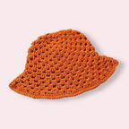 Orange crochet bucket hat on plain background