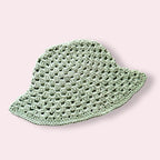 Pastel green crochet bucket hat on plain background