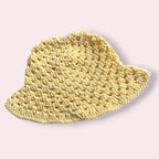 Pastel yellow crochet bucket hat on plain background