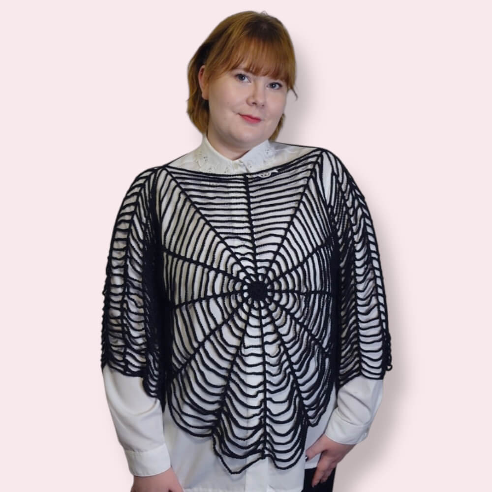 Person wearing a black spiderweb shirt with a plain background