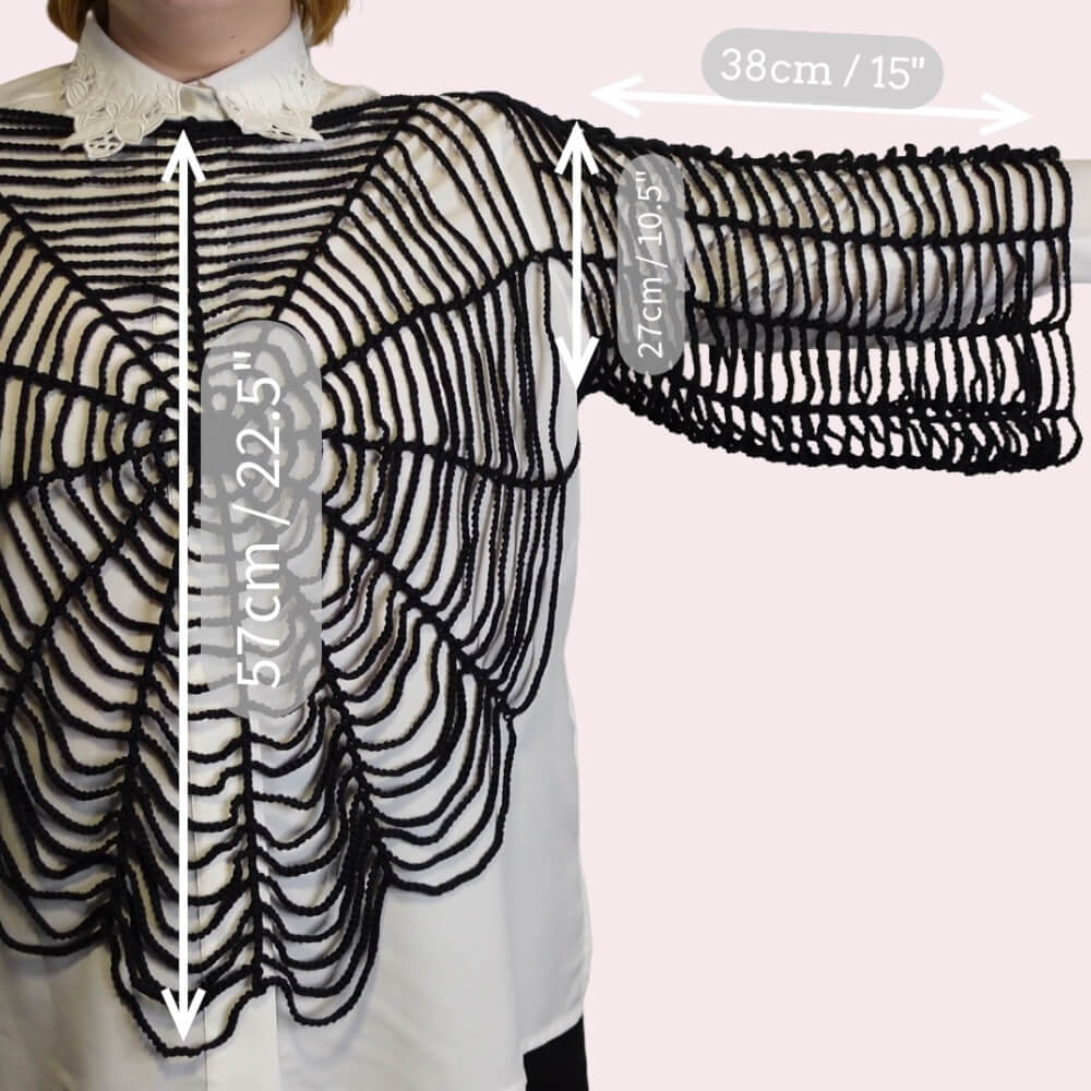 Person wearing a black spiderweb shirt with measurements on a plain background