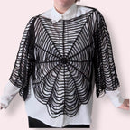 Person wearing black spiderweb top over white undershirt