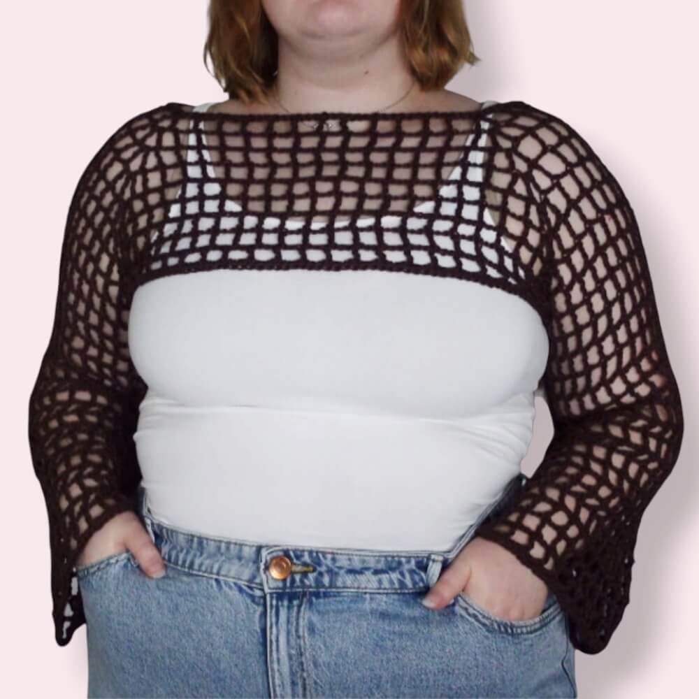 Person wearing brown crochet mesh sleeves on plain background