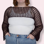 Person wearing brown crochet mesh sleeves on plain background