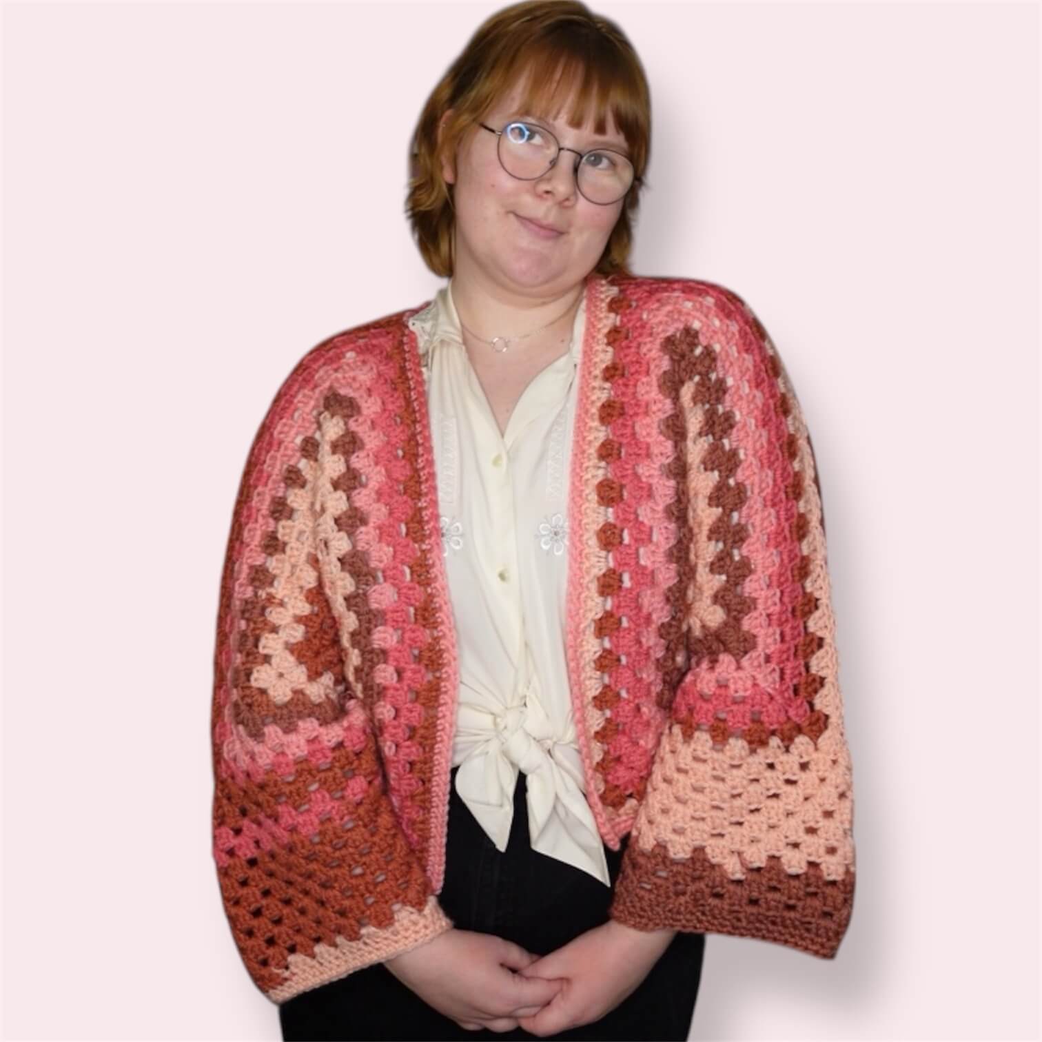 Person wearing pink crochet cardigan front view