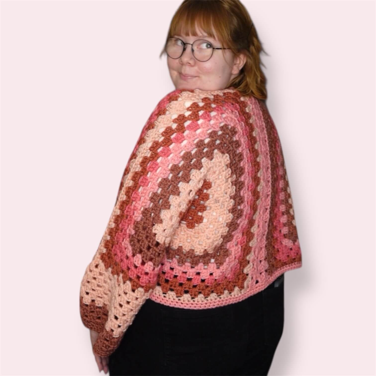 Person wearing pink crochet cardigan side view