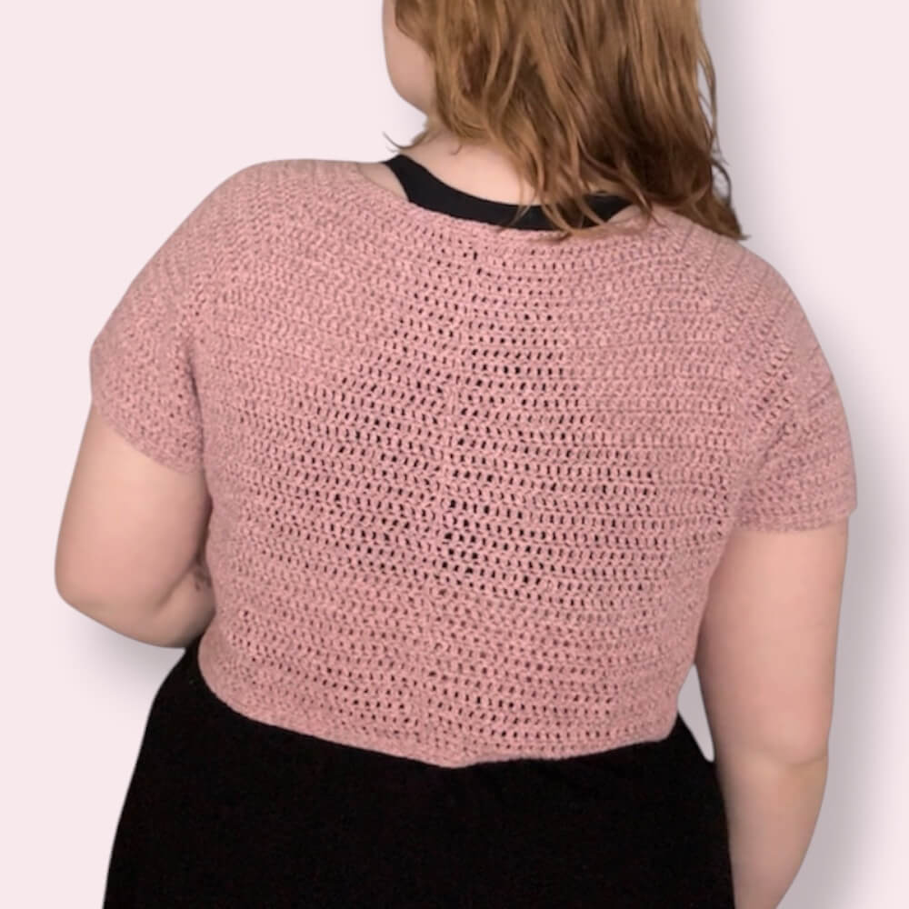 Person wearing pink crochet tshirt back view