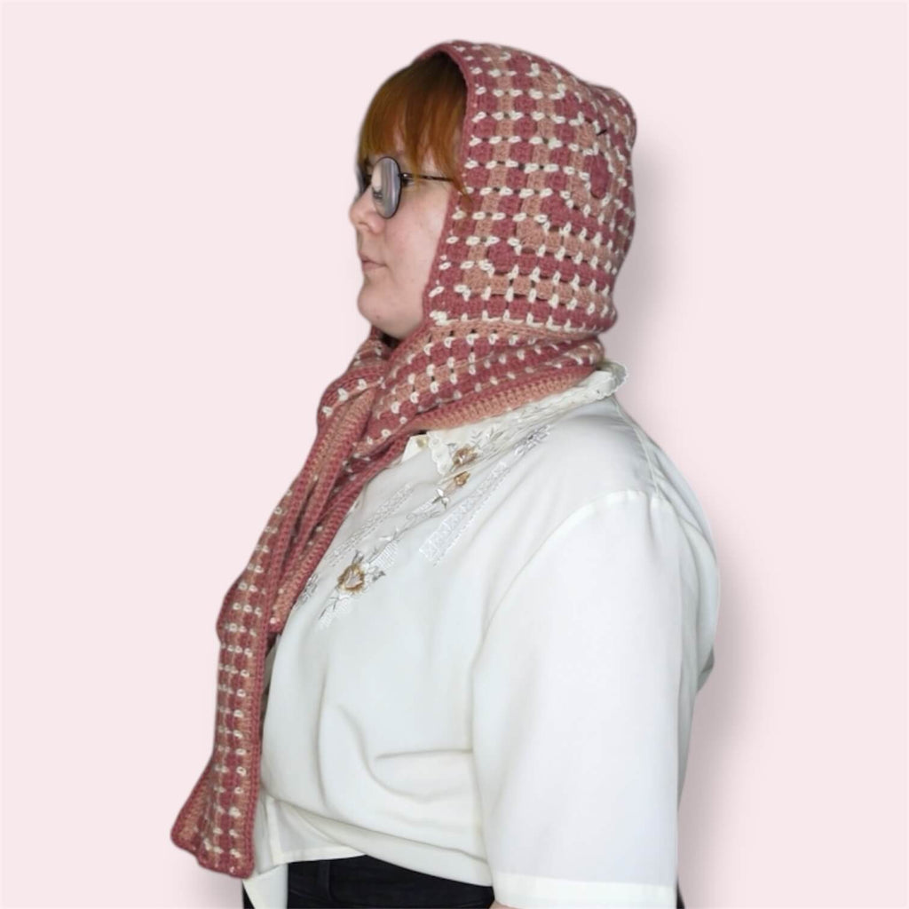 Person wearing pink hooded scarf side view