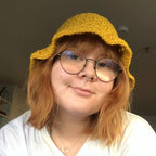 Person wearing yellow crocheted bucket hat