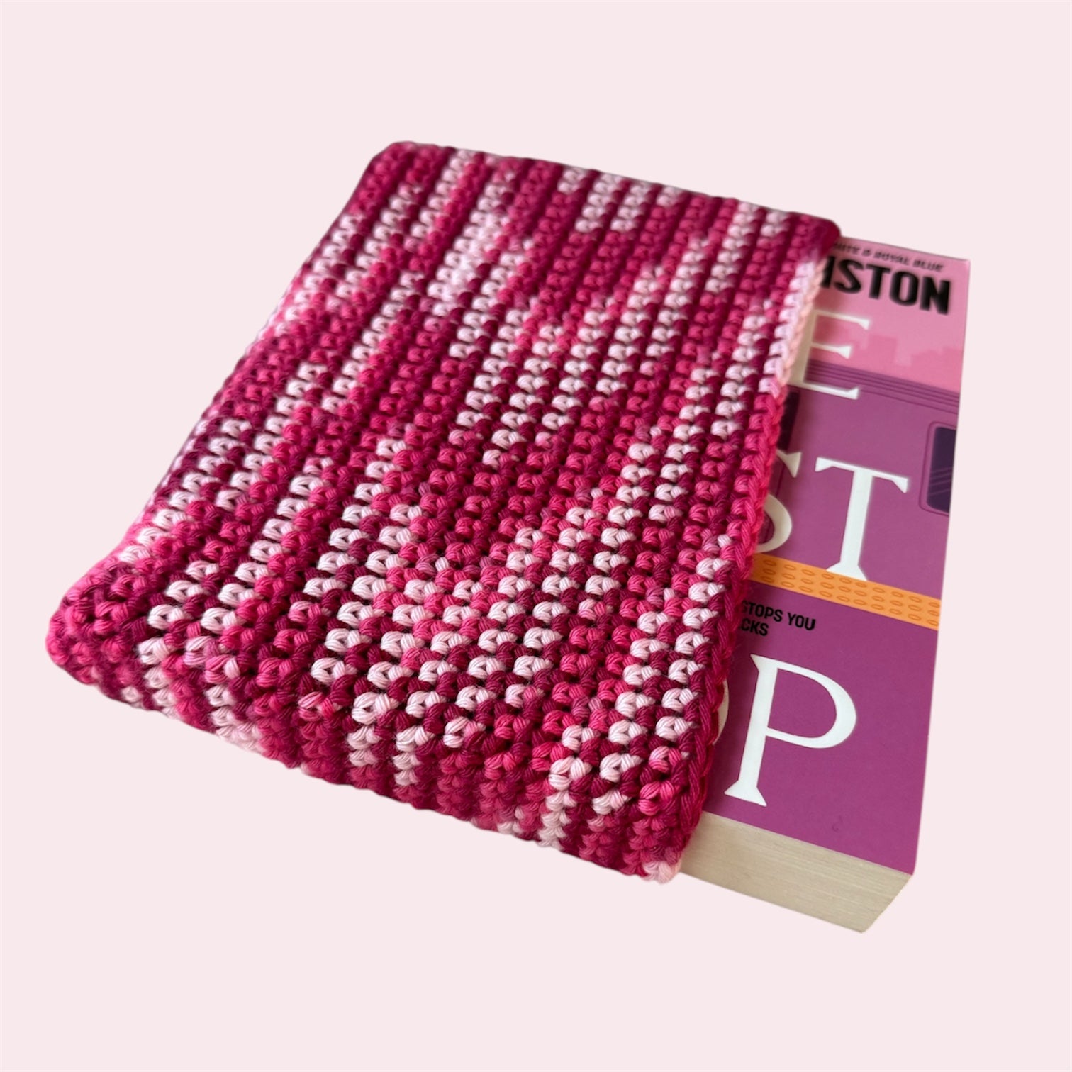 Pink book sleeve with a book inside on a pink background