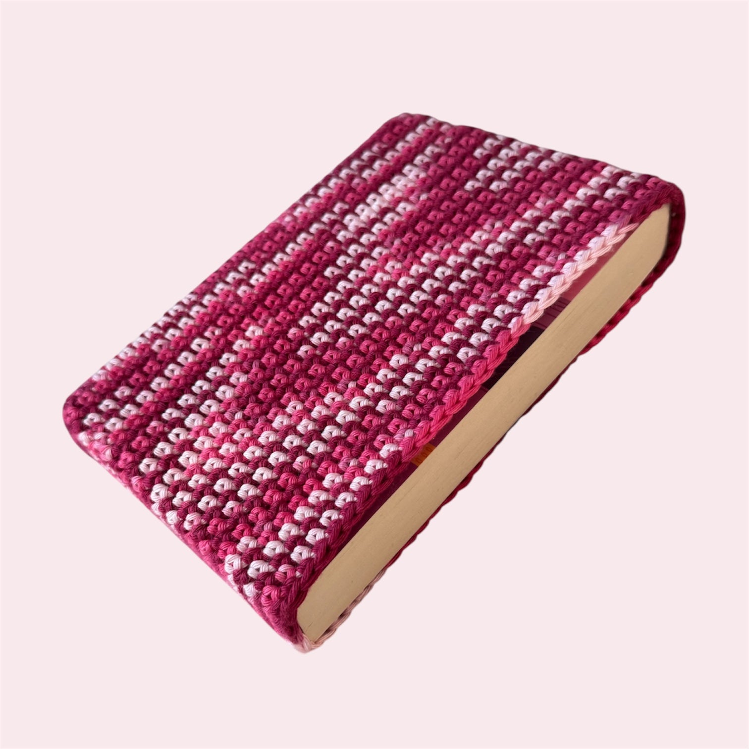Pink book sleeve with a book inside on a pink background