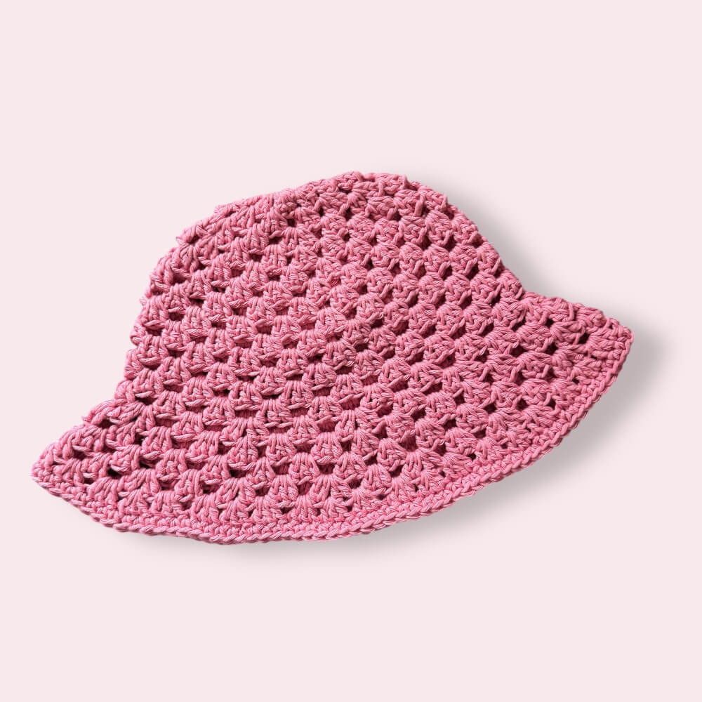 Pink crochet bucket hat on plain background