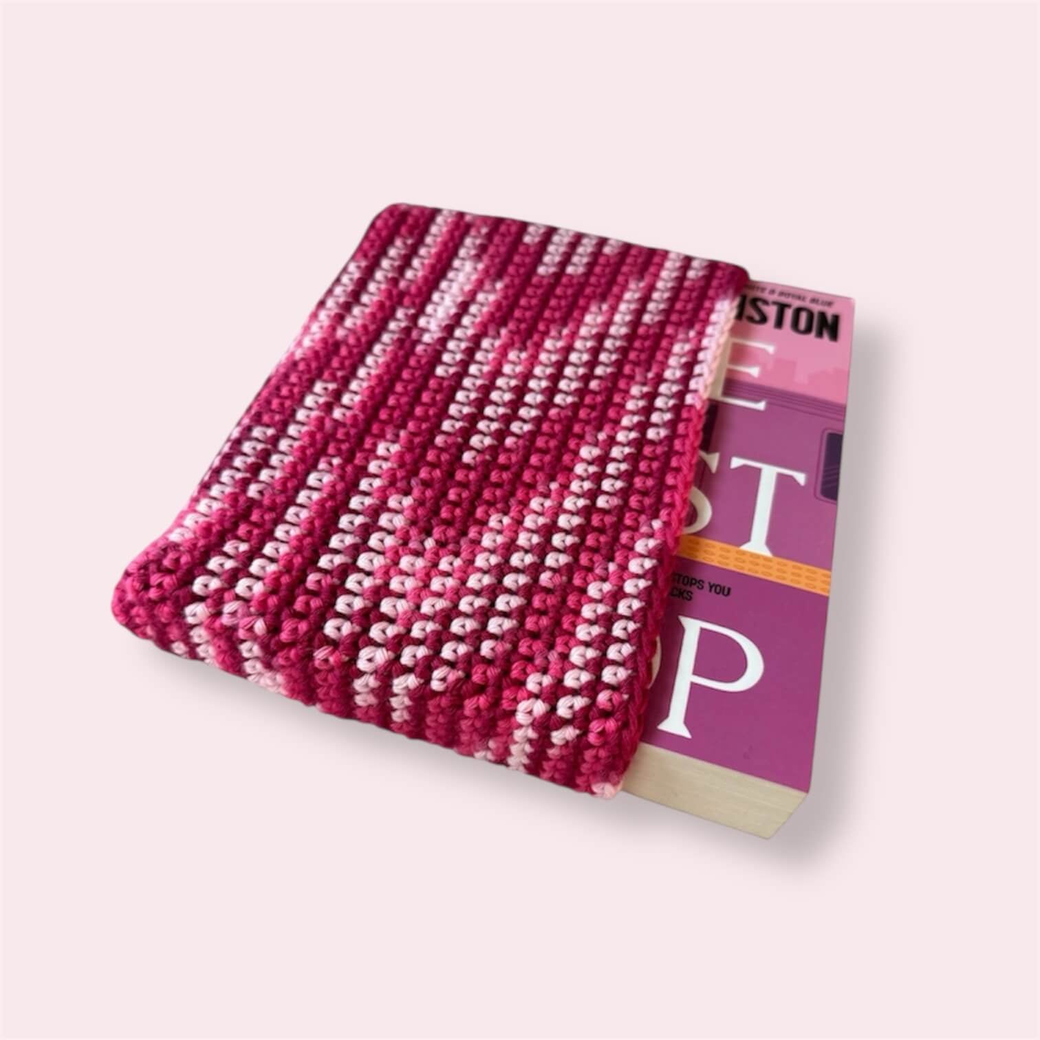 Pink crocheted book sleeve with a book inside