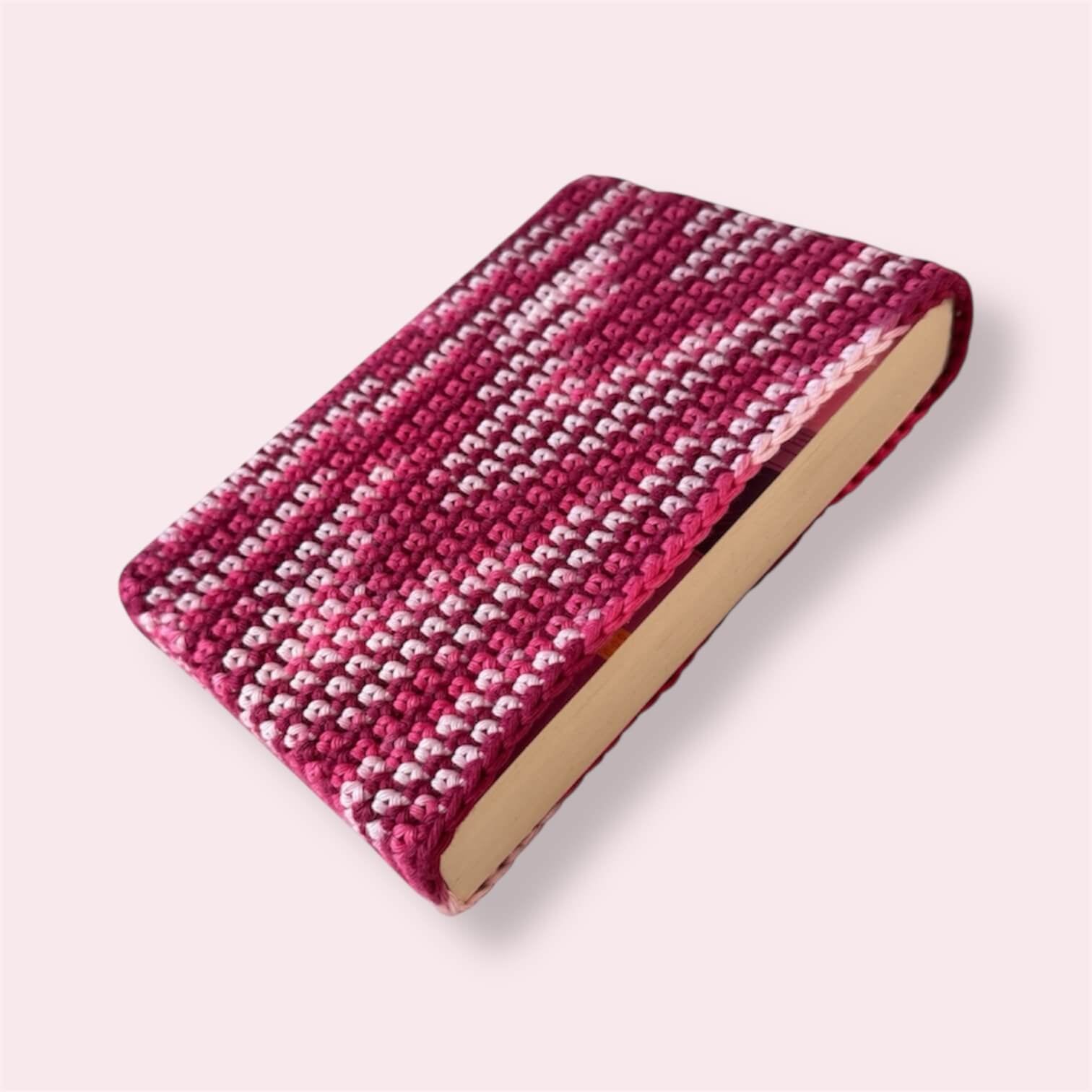Pink crocheted book sleeve with book inside side view