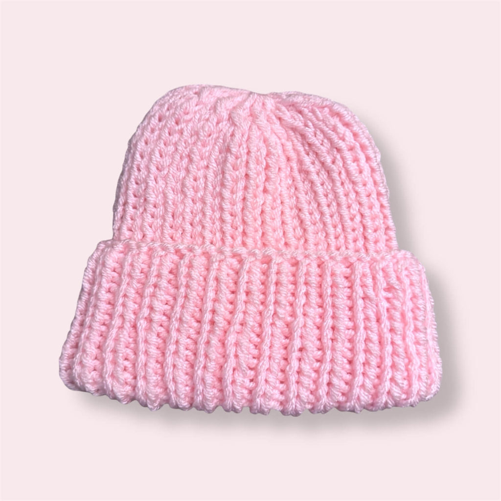 Pink handmade pink beanie on plain background