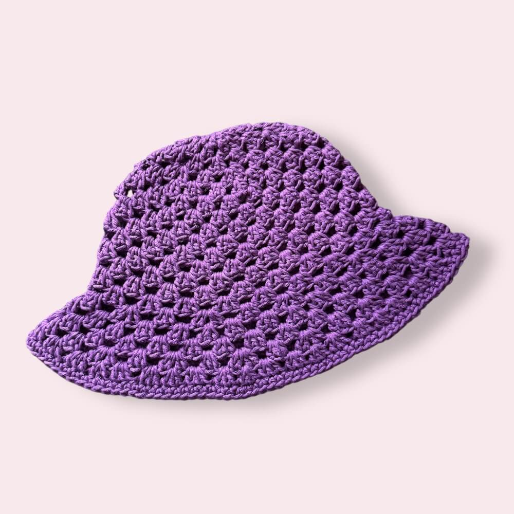 Purple crochet bucket hat on plain background